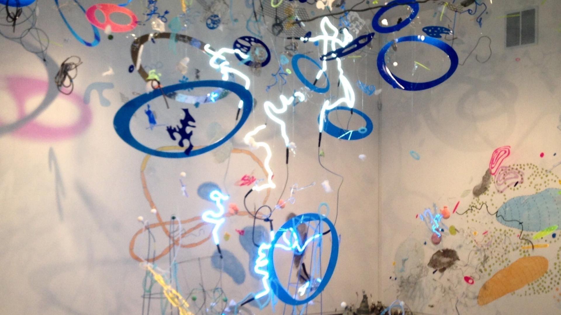 Mixed media art exhibit hanging from ceiling to floor