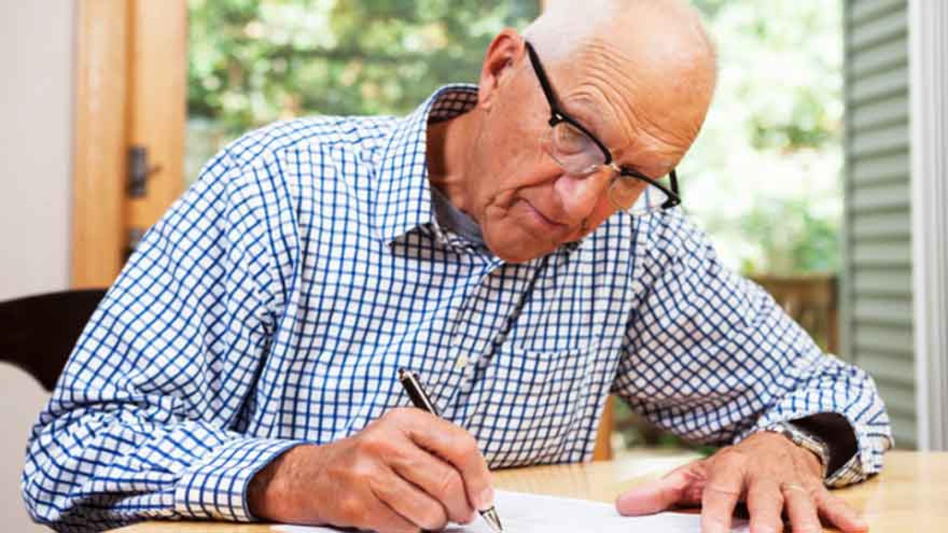 Older adult filling out paperwork.