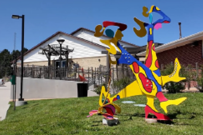 Colorful abstract art sculpture on lawn in front of arts and culture center