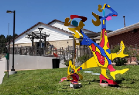 Colorful abstract art sculpture on lawn in front of arts and culture center