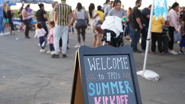 Summer Kickoff sign with crowd in the background