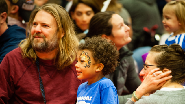Young boy and adults in a crowd looking to the left