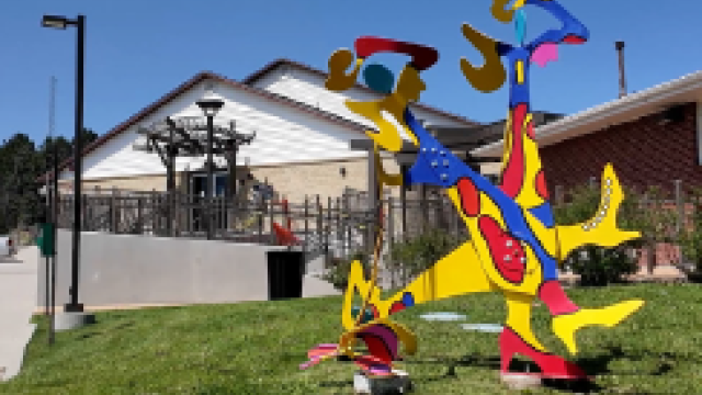 Colorful abstract art sculpture on lawn in front of arts and culture center
