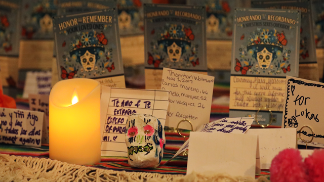 Yellow candle in front of day of the dead greeting cards at altar