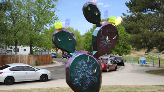A purple and blue cactus sculpture with different engravings on it.