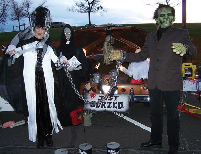 Frankenstein and Bride standing by a decorated trunk.