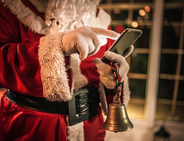 Santa holding a mobile phone.
