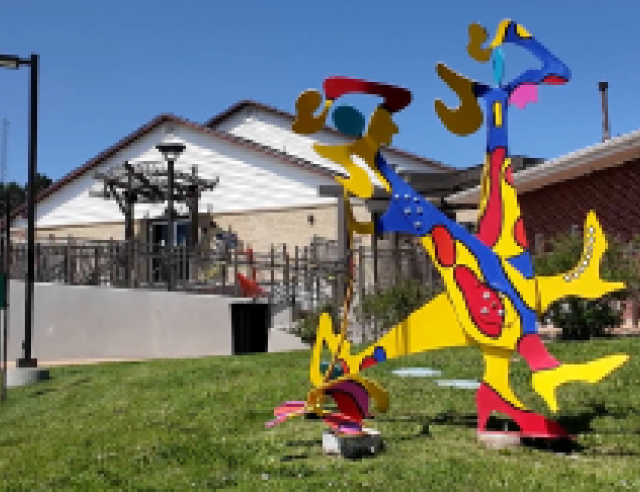 Colorful abstract art sculpture on lawn in front of arts and culture center