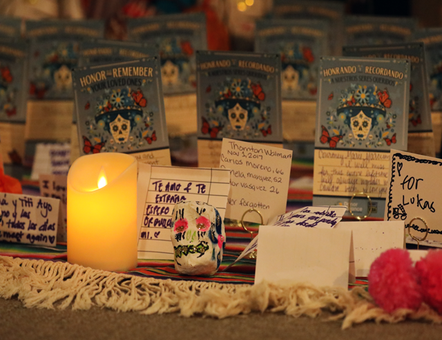 Yellow candle in front of day of the dead greeting cards at altar
