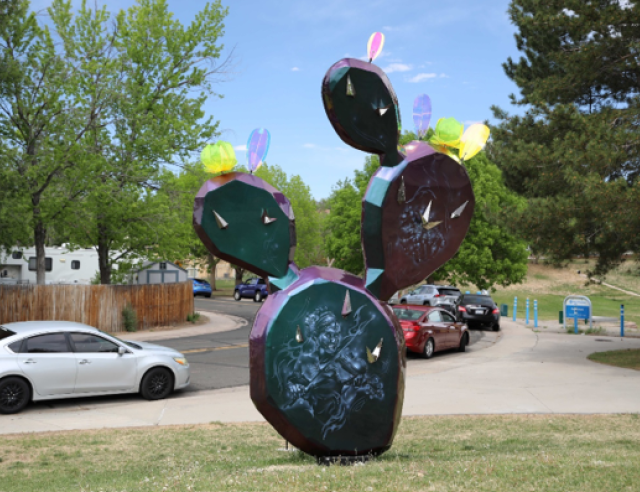 A purple and blue cactus sculpture with different engravings on it.