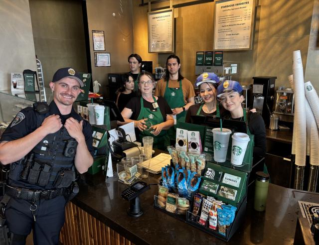 police officer standing at counter with coffee baristas