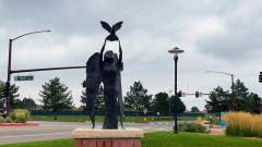 "Grace" bronze sculpture of a winged angel releasing a dove with dog tags.