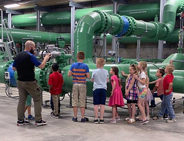 Kids at a water treatment plant with a Thornton guide.