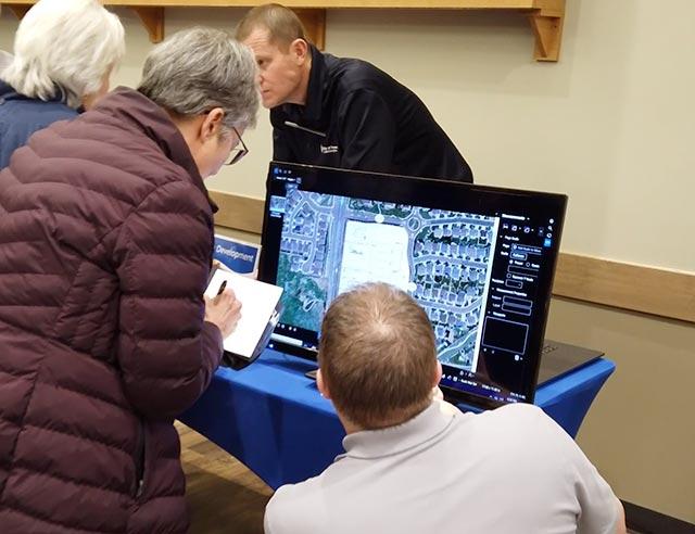 Senior person taking notes and looking at a map on a screen with a Thornton employee.